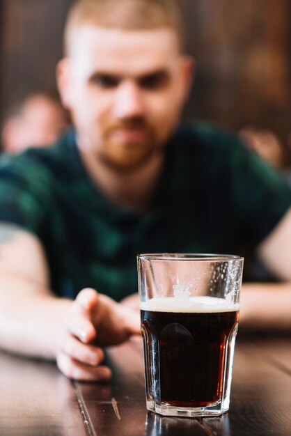 Mann, der Glas Rum über Schreibtisch nimmt