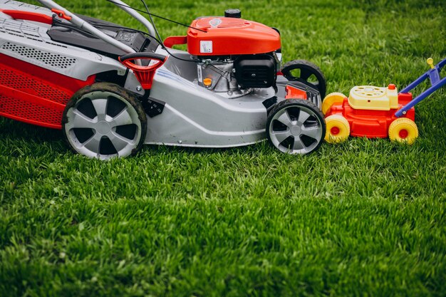 Mann, der Gras mit Rasenmäher im Hinterhof schneidet