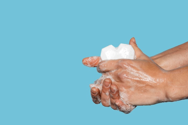 Kostenloses Foto mann, der hände mit einer herzförmigen weißen seife wäscht