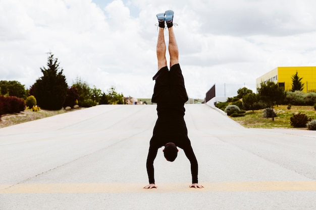 Kostenloses Foto mann, der handstandübung auf straße tut