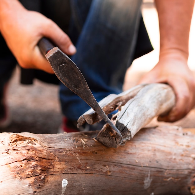 Mann, der Holz mit Axt schneidet