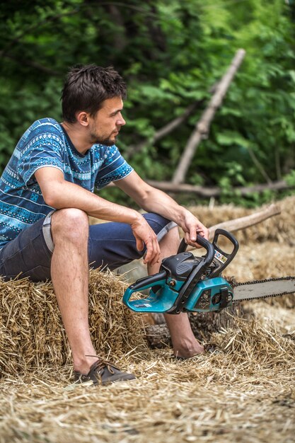 Mann, der Holz mit einer Kettensäge hackt