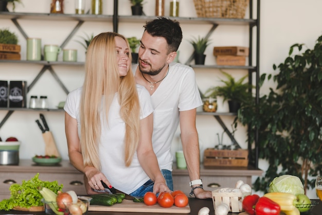 Mann, der ihre Frau schneidet Gemüse in der Küche liebt