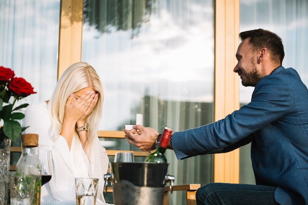 Kostenloses Foto mann, der ihrer schüchternen freundin verlobungsring gibt