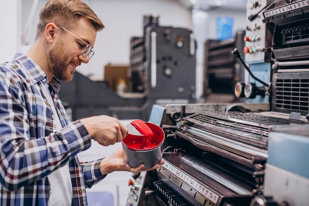 Mann, der im Druckhaus mit Papier und Farben arbeitet