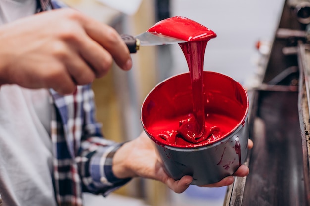 Mann, der im Druckhaus mit Papier und Farben arbeitet