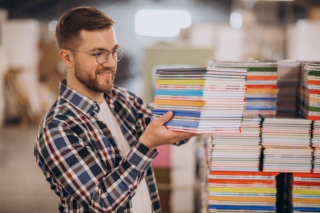 Mann, der im Druckhaus mit Papier und Farben arbeitet