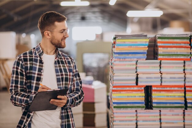 Mann, der im Druckhaus mit Papier und Farben arbeitet