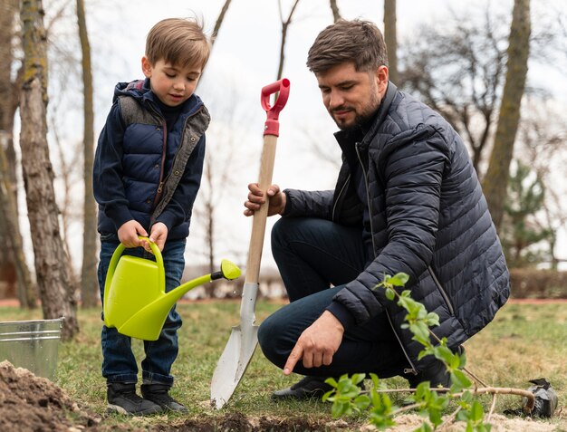 Mann, der in den Boden einen kleinen Baum plattiert