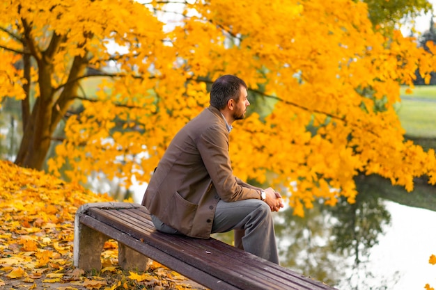 Mann, der in den Herbstpark geht