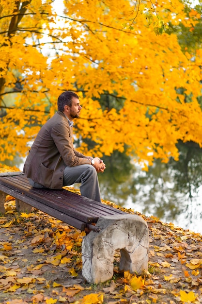 Mann, der in den Herbstpark geht