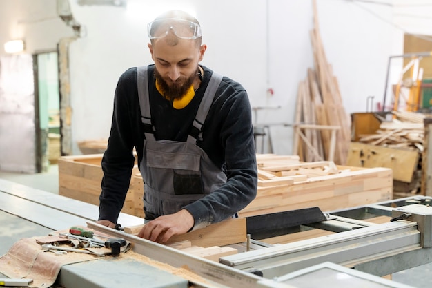 Kostenloses Foto mann, der in einem lager für mdf-platten arbeitet