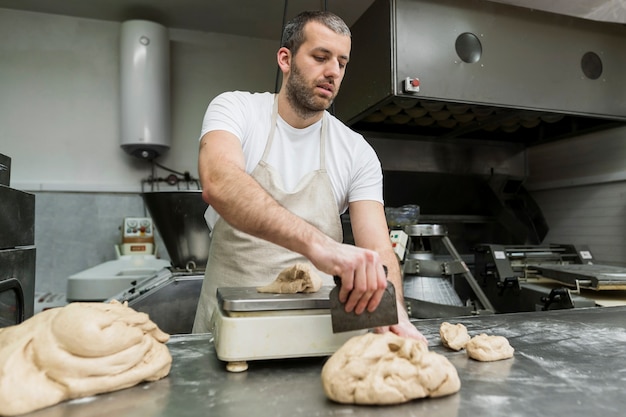 Kostenloses Foto mann, der in einer brotfabrik arbeitet