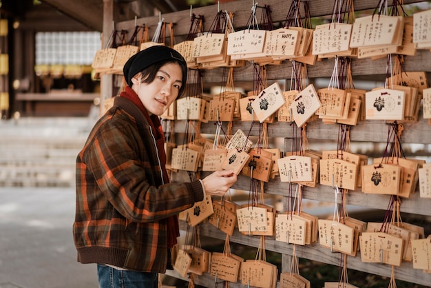 Kostenloses Foto mann, der japanische holzkarten betrachtet