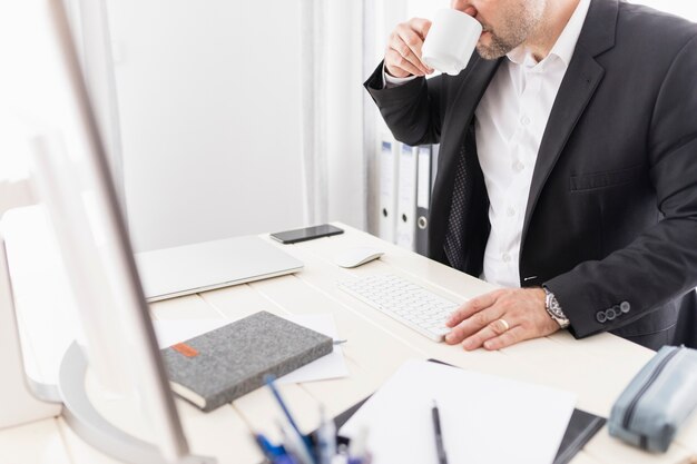 Mann, der Kaffee an seinem Job trinkt