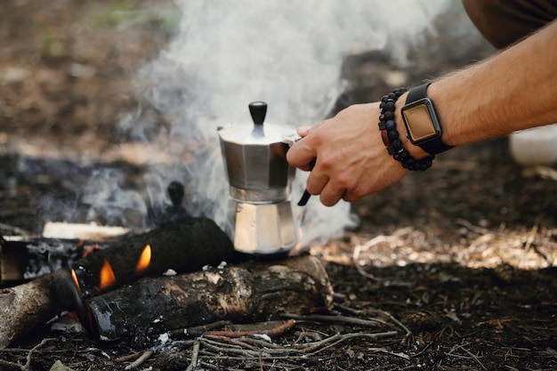 Mann, der Kaffee im Wald trinkt