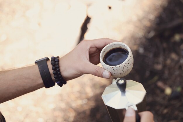 Mann, der Kaffee im Wald trinkt