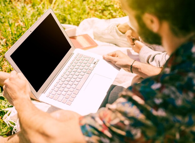 Mann, der Laptop auf Rest verwendet