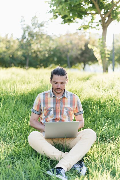 Mann, der Laptop im Park verwendet