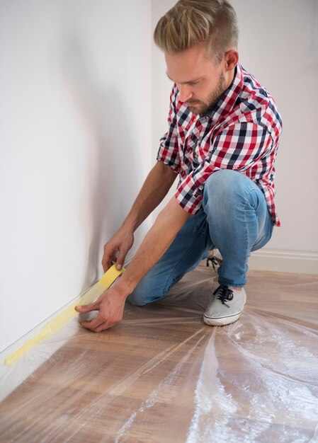 Mann, der Maßnahmen im zukünftigen Wohnzimmer ergreift