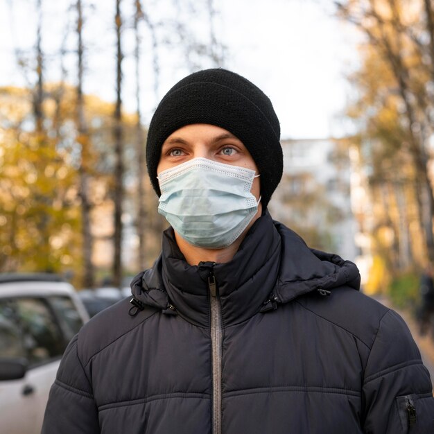 Mann, der medizinische Maske in der Stadt trägt