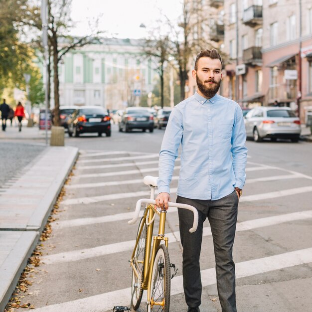 Mann, der mit Fahrrad auf Straßenrand geht