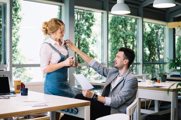 Mann, der mit Frau im Büro flirtet