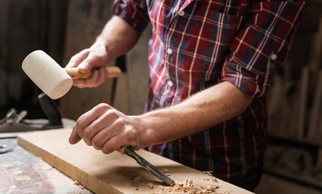 Mann, der mit Holz in der Werkstatt arbeitet