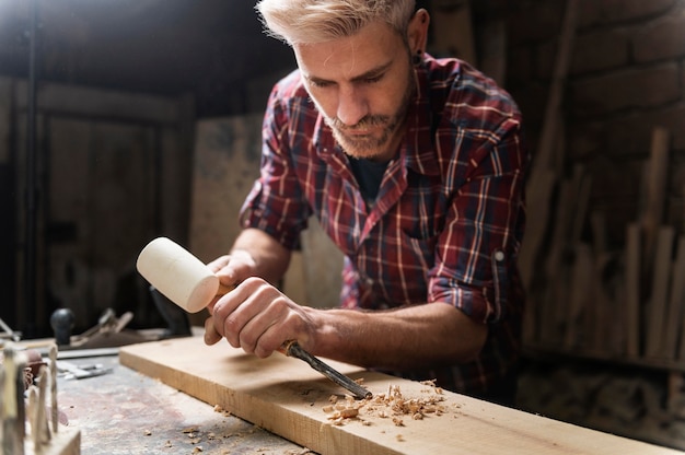 Mann, der mit Holz in der Werkstatt arbeitet