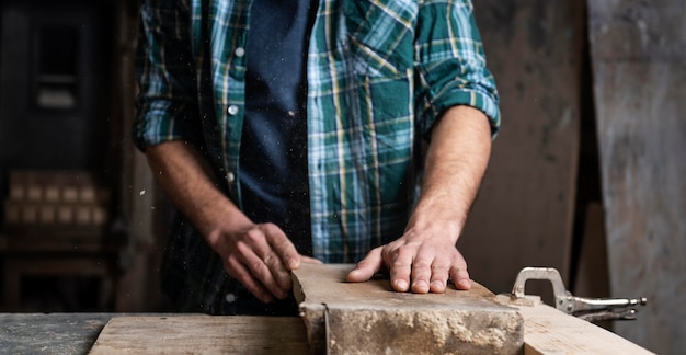 Mann, der mit Holz in der Werkstatt arbeitet