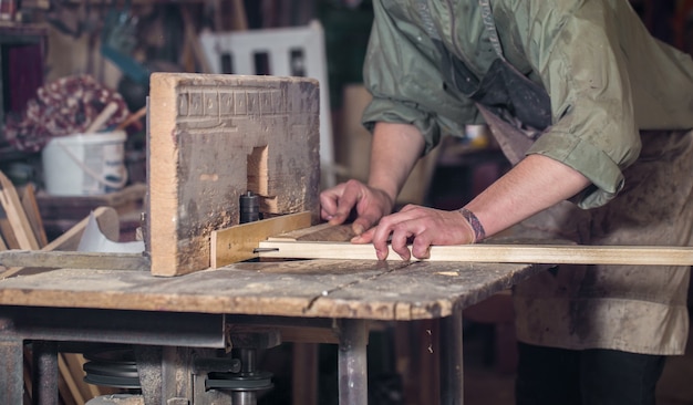 Mann, der mit Holzprodukt auf der Maschine arbeitet