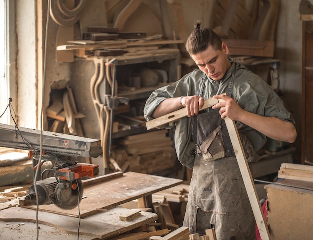 Kostenloses Foto mann, der mit holzprodukt auf der maschine arbeitet