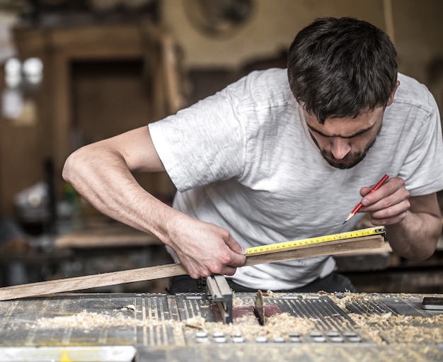 Mann, der mit Holzprodukt auf der Maschine arbeitet