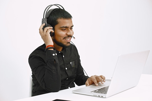 Mann, der mit laptop arbeitet. indischer versand- oder hotline-mitarbeiter.