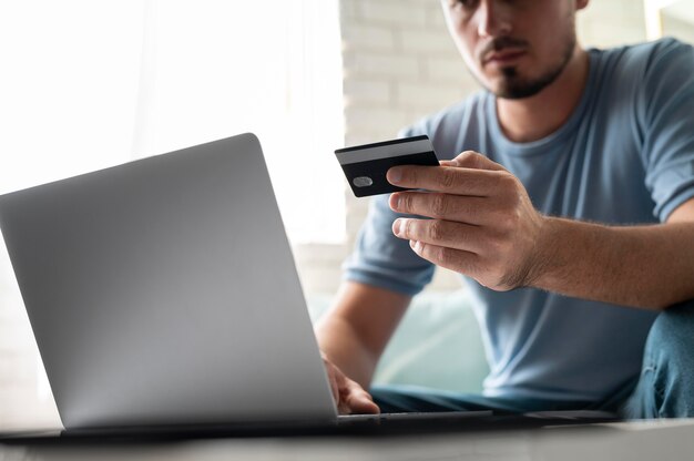 Mann, der mit seiner Kreditkarte online um eine Bestellung spielt