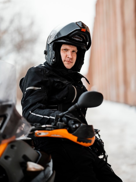 Mann, der Motorrad am Wintertag reitet