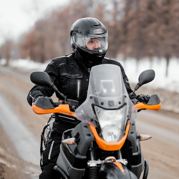 Mann, der Motorrad am Wintertag reitet