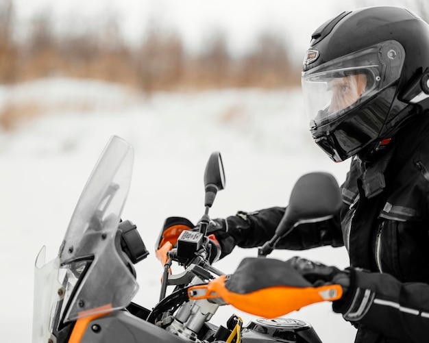 Mann, der Motorrad am Wintertag reitet