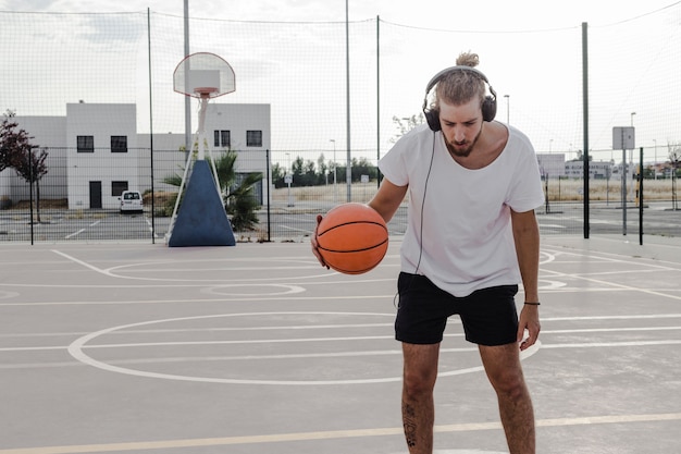 Mann, der Musik beim Spielen des Basketballs hört