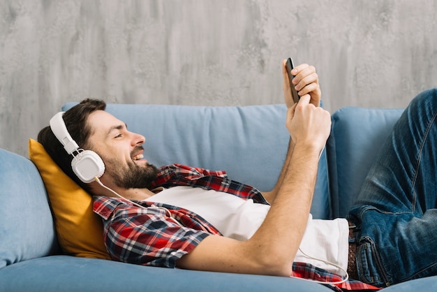Mann, der Musik hört und Smartphone verwendet