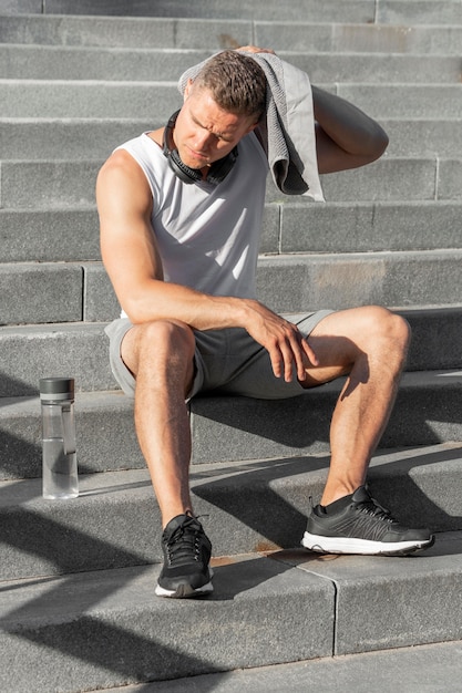 Mann, der nach dem Training auf Treppen sitzt