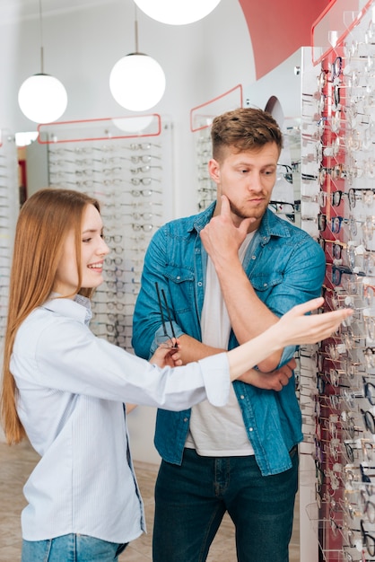 Kostenloses Foto mann, der nach neuen gläsern am optometriker sucht