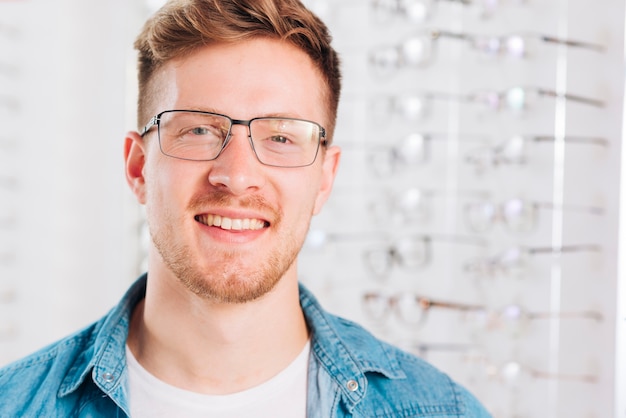 Kostenloses Foto mann, der nach neuen gläsern am optometriker sucht