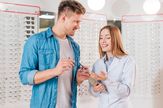 Kostenloses Foto mann, der nach neuen gläsern am optometriker sucht