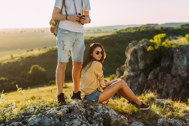 Mann, der nahe der Frau sitzt auf Felsen steht