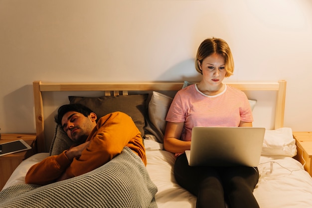 Kostenloses Foto mann, der nahe frau mit laptop schläft