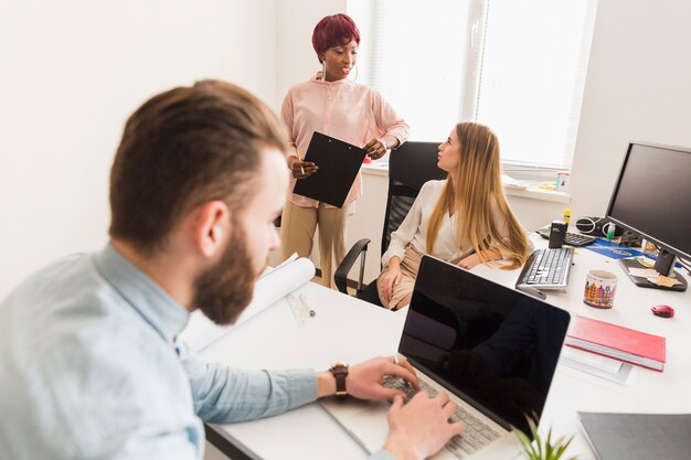 Mann, der nahe sprechenden Kollegen arbeitet