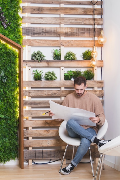 Mann, der Plan im Büro aufpasst