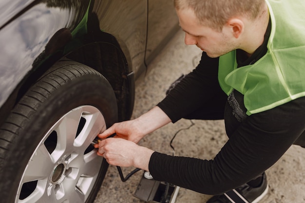 Mann, der Rad nach einer Autopanne wechselt