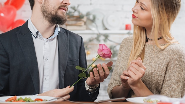 Mann, der rosafarbene Rose Frau darstellt